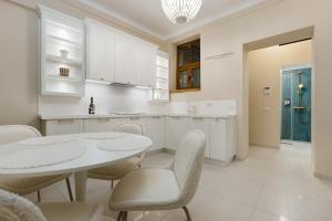 a kitchen with white cabinets and a table and chairs at 1910 Boutique Hotel in Braşov