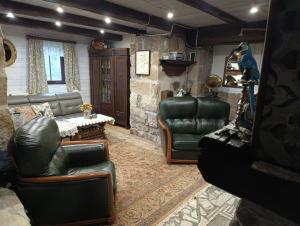 a living room with leather chairs and a table at Chata Kataryniarza in Karłów