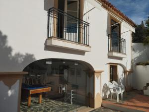 Casa blanca con patio con mesa y sillas en Casa Do Ginjal by NaturAlegre en Marvão