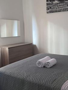 a bedroom with two towels on a bed with a mirror at Reversal apartment in Santa Marinella