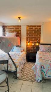 1 dormitorio con 2 camas y pared de ladrillo en Apartamento Vista Hermosa B, en Sololá
