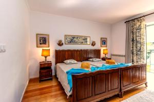 a bedroom with a large wooden bed with blue sheets at Casa Do Ginjal by NaturAlegre in Marvão +92 photos