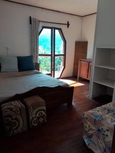 a bedroom with a bed and a large window at maison atypique, belle vue, belles chambres in Yaoundé