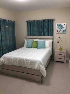 a bedroom with a large bed with blue curtains at Jamaica Reggae Villa in Lucea
