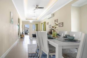 盧西的住宿－Jamaica Reggae Villa，一间配备有白色桌椅的用餐室