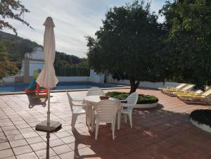 a patio with a table and chairs and an umbrella at Casa Do Ginjal by NaturAlegre in Marvão
