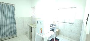 a white bathroom with a sink and a shower at Suíte aconchegante e completa! Entrada independente em nova Iguaçu in Nova Iguaçu
