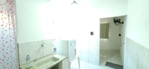 a white bathroom with a sink and a shower at Suíte aconchegante e completa! Entrada independente em nova Iguaçu in Nova Iguaçu