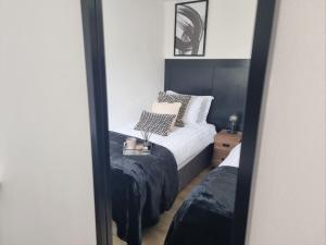 espejo reflejo de una cama en un dormitorio en Modern House Coventry City Centre with Parking en Coventry