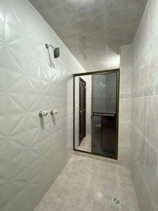 uma casa de banho com um espelho e um chuveiro em Hotel Fontibon em Bogotá