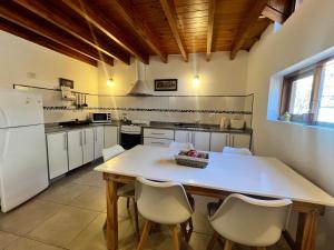 a kitchen with a table and white appliances at Noreen Departamentos in San Martín de los Andes