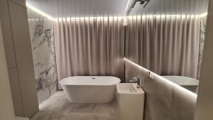 a bathroom with a tub and a sink and a toilet at Villa Blanca in Cedzyna +27 photos