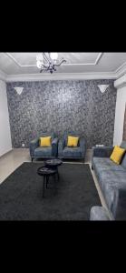 Sala de estar con 2 sofás y mesa en Joli appartement ngor / Almadies en Ngor