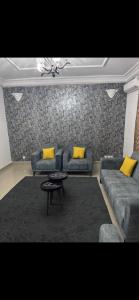 a living room with two couches and a table at Joli appartement ngor / Almadies in Ngor