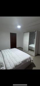 a bedroom with a white bed and a window at Joli appartement ngor / Almadies in Ngor