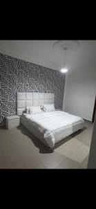a white bed in a room with a wall at Joli appartement ngor / Almadies in Ngor