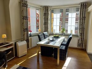 a living room with a table and chairs and windows at Brautröckchen in Bullay +5 photos
