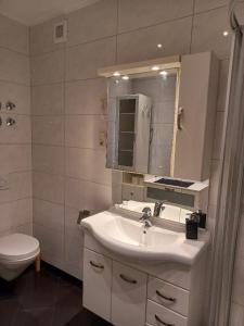 uma casa de banho com um lavatório, um WC e um espelho. em Brautröckchen em Bullay