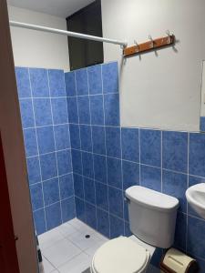 a blue tiled bathroom with a toilet and a sink at Antiquilla in Arequipa