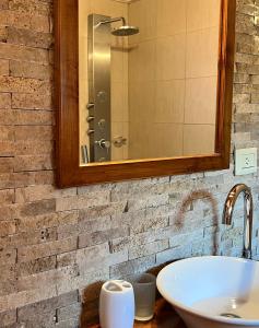 bagno con lavandino e specchio di Departamentos Turismo de un dormitorio y dos dormitorios a San Martín de los Andes