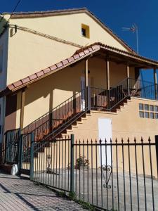 a house with a staircase in front of a fence at Bonito apartamento Cistierna in Cistierna