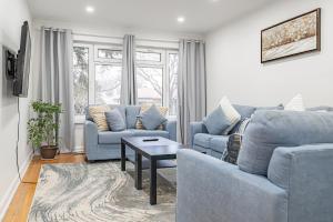 a living room with two blue couches and a table at Littlewood Properties in Toronto