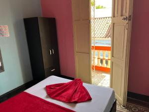 卡塔赫納的住宿－La Viduka Hostel，红色布,坐在房间里的床边