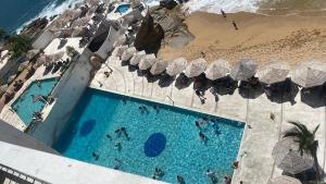 an overhead view of a swimming pool next to a beach at Torres Gemelas Suite VIP Frontal 607 in Acapulco
