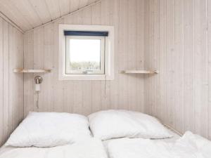 een bed in een kleine kamer met een raam bij Two-Bedroom Holiday home in Kalundborg 2 in Børkop