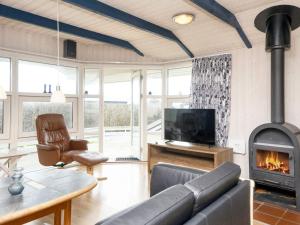 een woonkamer met een bank en een open haard bij Two-Bedroom Holiday home in Kalundborg 2 in Børkop