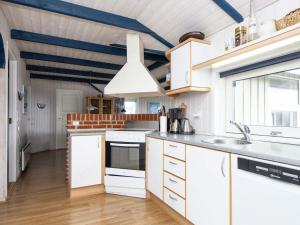 een keuken met witte kasten en een blauw plafond bij Two-Bedroom Holiday home in Kalundborg 2 in Børkop