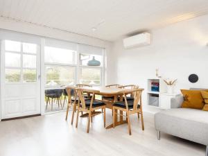 una sala da pranzo con tavolo, sedie e divano di 6 person holiday home in B rkop a Børkop