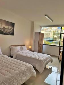 a bedroom with two beds and a large window at HOSPEDAJE BOGOTA CENTRO in Bogotá