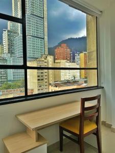 um banco de madeira sentado em frente a uma janela com vista em HOSPEDAJE BOGOTA CENTRO em Bogotá