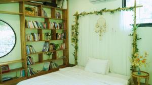 a bedroom with a bed and a book shelf at Dốc Chill - Villa gần Ba Vì, view núi, gần hồ, 40ph đi từ trung tâm Hà Nội in Hanoi
