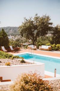 - une piscine avec des chaises longues et des chaises dans un complexe dans l'établissement Fátima-Ourém - Quinta da Luz - breakfast included, à Ourém