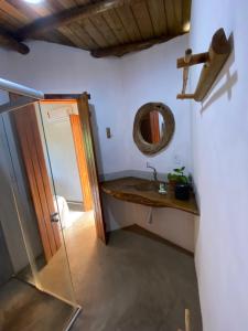 a bathroom with a sink and a mirror at Pousada Dendê Caraiva in Caraíva