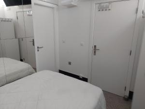 um quarto com 2 camas e armários brancos em The Ketchs House em Montijo