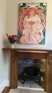 a painting of a woman on top of a fireplace at The Bank House in Mount Victoria