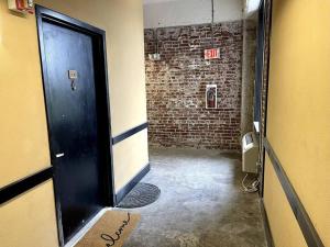 a hallway with a black door and a brick wall at Downtown Memphis Luxury Condo in Memphis +10 photos