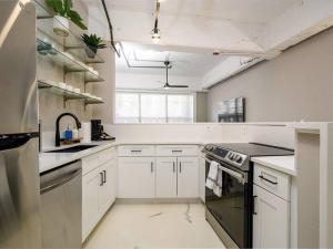 a white kitchen with a sink and a stove at Downtown Memphis Luxury Condo in Memphis