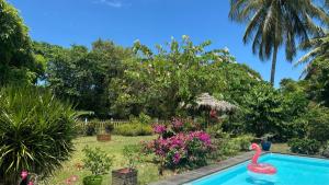 une piscine avec un flamingo rose dans un jardin dans l'établissement Villa Standing Accès Privé Plage, à Sainte-Rose
