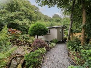 a small shed in the middle of a garden at Woodmans Huts in Haverthwaite