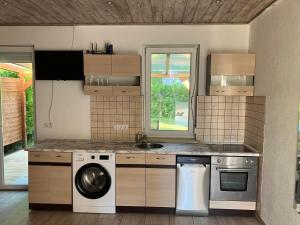a kitchen with a washing machine and a sink at Liget in Balatonföldvár