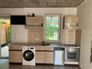 a kitchen with a washing machine and a sink at Liget in Balatonföldvár +12 photos