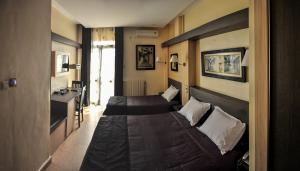 a hotel room with two beds and a desk at Hôtel le convivial in Jijel