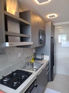 a kitchen with a sink and a stainless steel refrigerator at Casa 6 Encanto dos Mares in Itajaí +25 photos