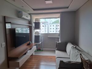 a living room with a couch and a flat screen tv at Casa 6 Encanto dos Mares in Itajaí