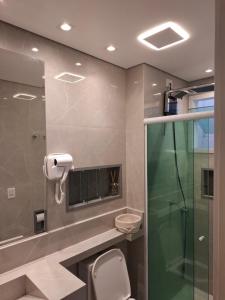a bathroom with a toilet and a glass shower at Casa 6 Encanto dos Mares in Itajaí