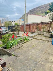 フォート・ウィリアムにあるWallace Houseの柵前の赤い花の庭園